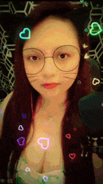 a woman wearing glasses and a cat ear headband has hearts around her face