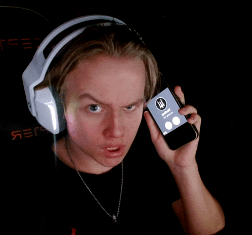 a young man wearing headphones is holding a cell phone that says ' emergency ' on it