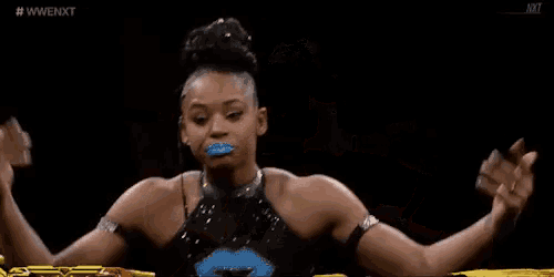 a woman is making a funny face in a wrestling ring while wearing a blue lip balm .