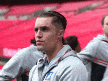 a man wearing a grey hoodie with the number 7 on the front