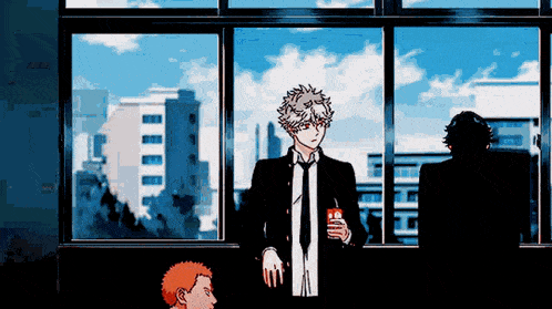 a man in a suit and tie is standing in front of a large window holding a drink .