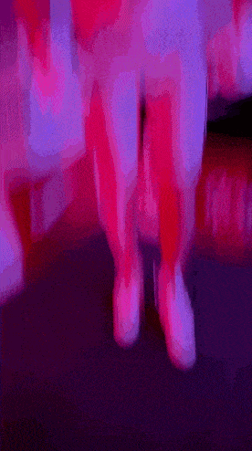 a blurry picture of a person 's legs in pink and purple lighting