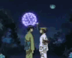 a man and a woman are standing in front of fireworks .