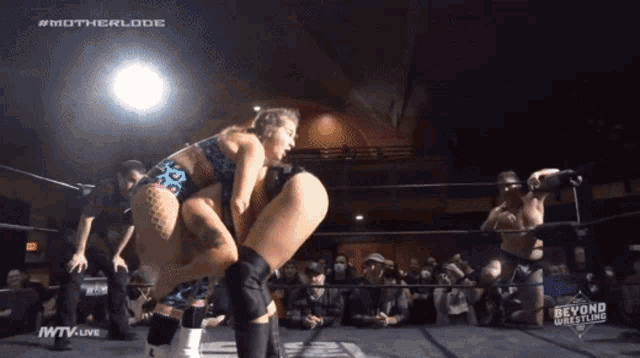 a female wrestler is being lifted in the air by another wrestler