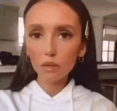 a close up of a woman taking a selfie in a kitchen .