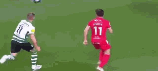 a soccer player in a red jersey is being tackled by another player on the field .