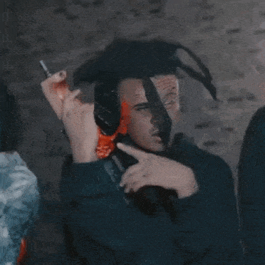 a man is holding a gun and making a middle finger gesture .