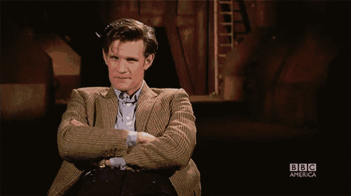a man in a suit is sitting with his arms crossed in front of a sign that says nhaa