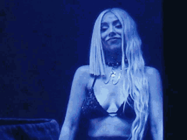 a woman in a bikini is singing into a microphone on a stage