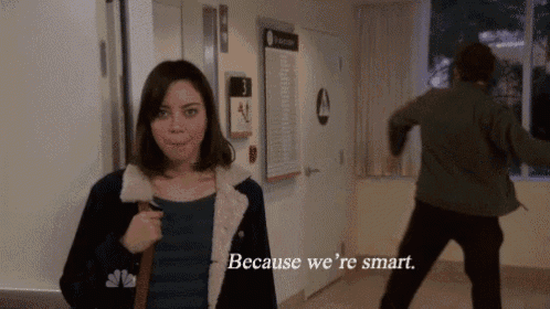 a man and a woman are standing in a hallway and the woman says because we 're smart