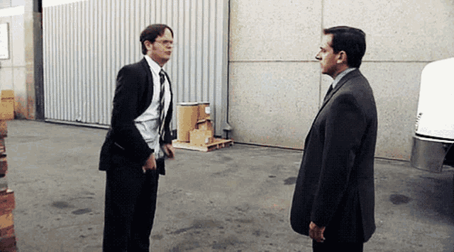 a man in a suit and tie is standing next to another man in a suit and tie