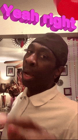 a man wearing a white shirt and a black hat stands in front of a sign that says yeah right