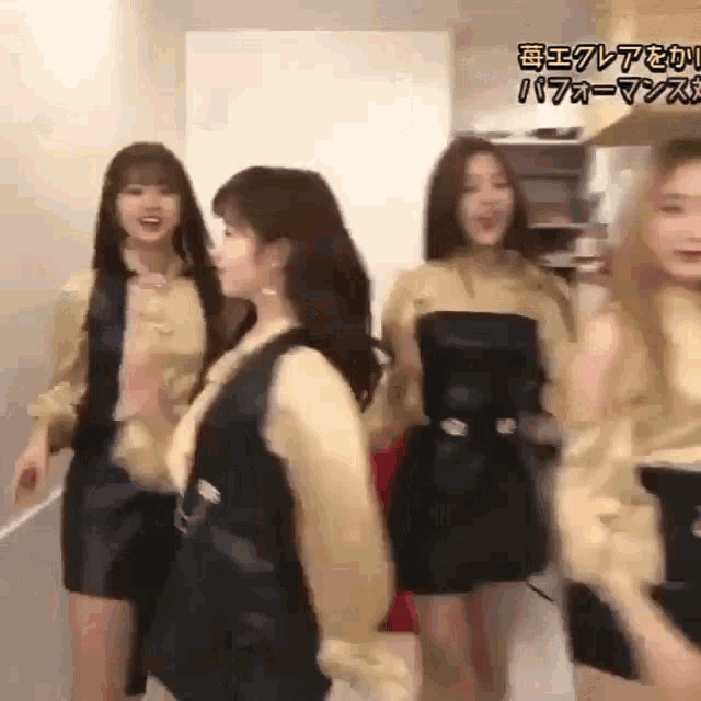 a group of young women are dancing together in a room with chinese writing on the wall behind them .