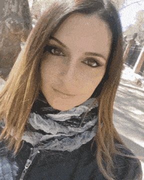 a woman wearing a scarf and a jacket with a zipper on the front