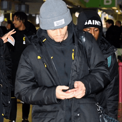 a man wearing a black hat that says saint on it