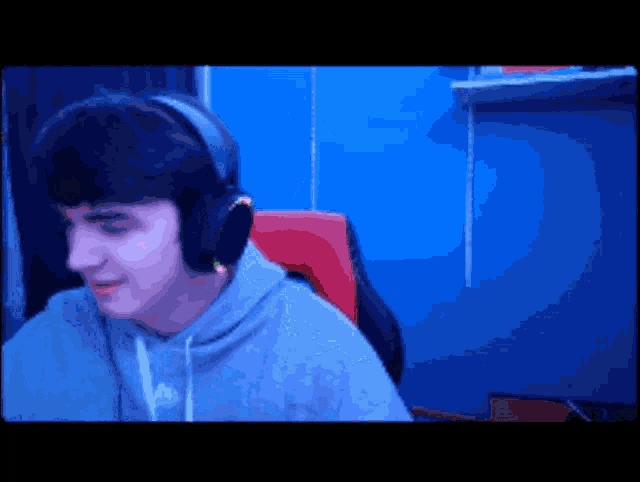 a man wearing headphones is sitting in front of a computer screen