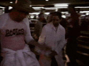 a man wearing a pink shirt that says ' bugs ' on it