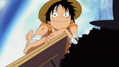 monkey d luffy from one piece leans on a table