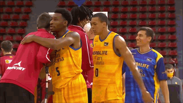 a group of basketball players are hugging each other and one of them has the number 0 on his jersey