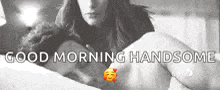 a man and a woman are laying in bed with the words `` good morning handsome '' above them .