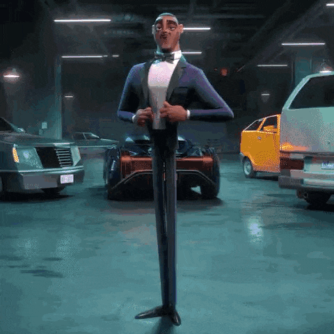 a man in a tuxedo and bow tie is standing in a parking garage .