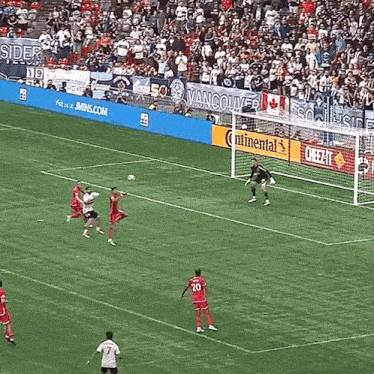 a soccer game is being played in front of a banner that says vancouver on it
