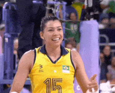 a woman is wearing a yellow jersey with the number 15 on it .