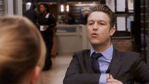 a man in a suit and tie talking to a woman