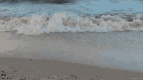 a close up of a wave breaking on a beach .