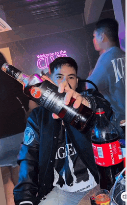 a man is holding a bottle of bacardi and a bottle of coca cola