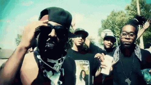 a group of young men are posing for a picture with one wearing a black shirt with a picture of a woman on the front