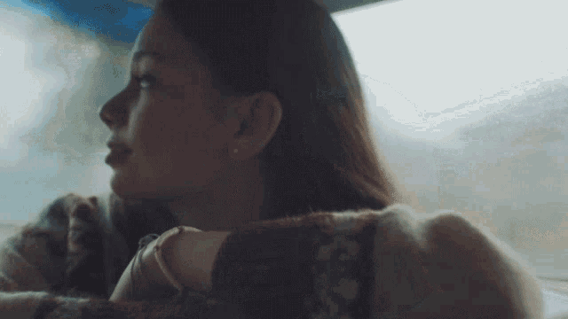 a woman in a car looks out the window