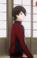 a young boy in a red and black jacket is standing in front of a window .