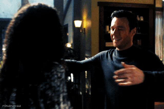 a man is hugging a woman in a room with a watermark that says rinamyaa