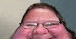 a close up of a man 's face with glasses and a red face .