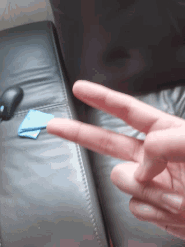 a person 's finger is pointing to a blue piece of paper that says ' a ' on it