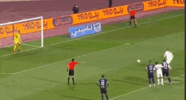 a soccer game is being played on a field with advertisements on the side
