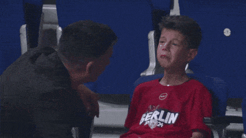 a boy in a berlin shirt is crying