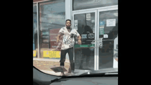 a man is standing in front of a store with a sign that says play here