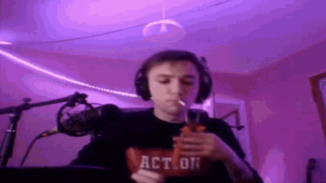 a man wearing headphones is smoking a cigarette and holding a bag that says act on