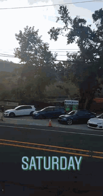 a row of cars are parked on the side of the road and the date is saturday