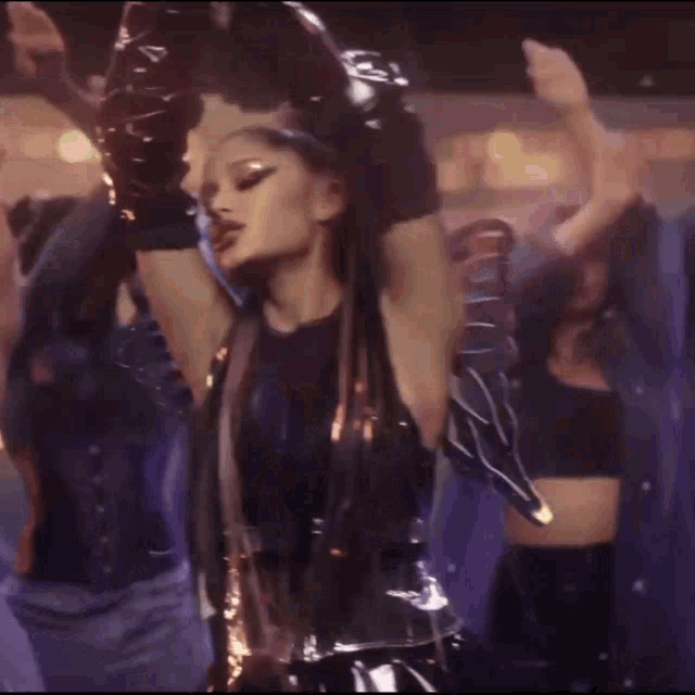 a woman covering her ears with her hands while dancing in front of a crowd