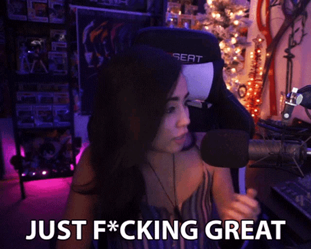 a woman sitting in front of a microphone with just f * cking great written on the bottom