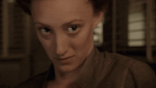 a close up of a woman 's face with a dark background