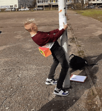 a man leaning against a pole with a box on his back that says ' a ' on it