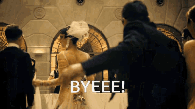 a woman in a wedding dress is dancing with a man in a tuxedo and the word byeee is written on the screen