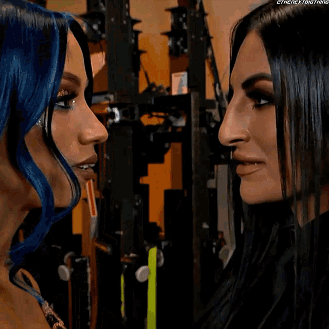 two women are looking at each other and one of them is wearing a necklace that says ' the next thing ' on it
