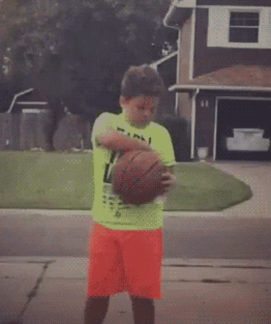 a boy wearing a shirt that says easy the win is holding a basketball