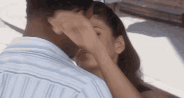 a man and a woman are hugging and kissing .