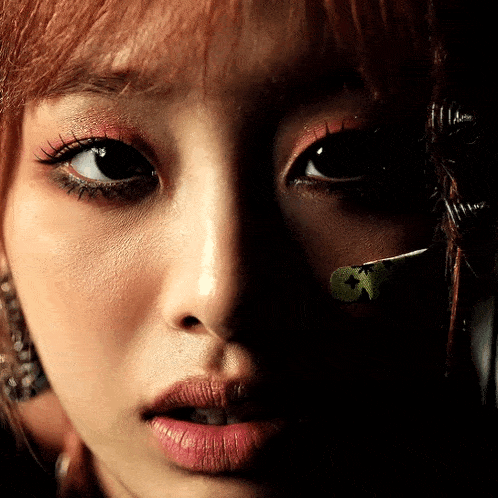 a close up of a woman 's face with a green sticker on her eye